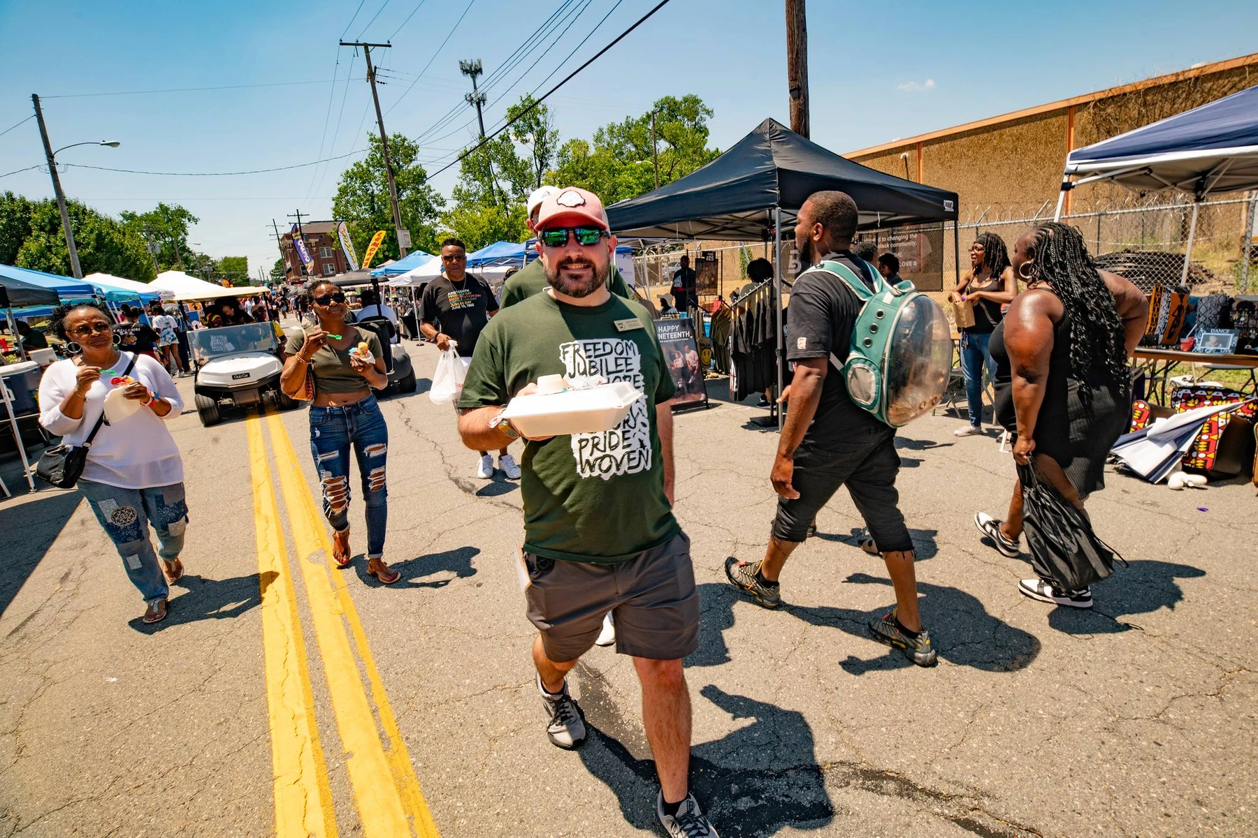 Ryan Tiffin at a live outdoor event with guests and production activity in the background