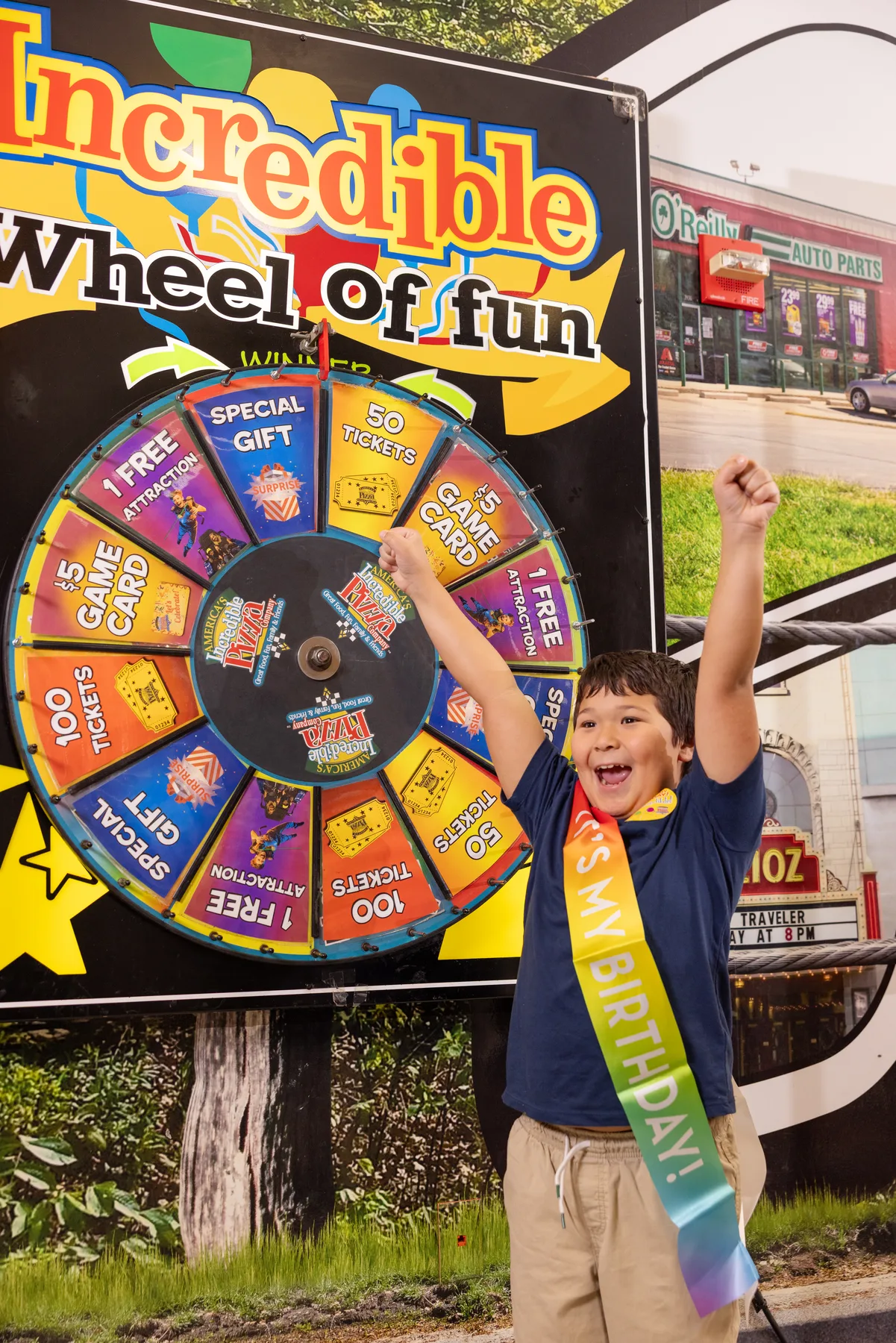 Young birthday guest celebrating beside an Incredible Wheel of Fun activation