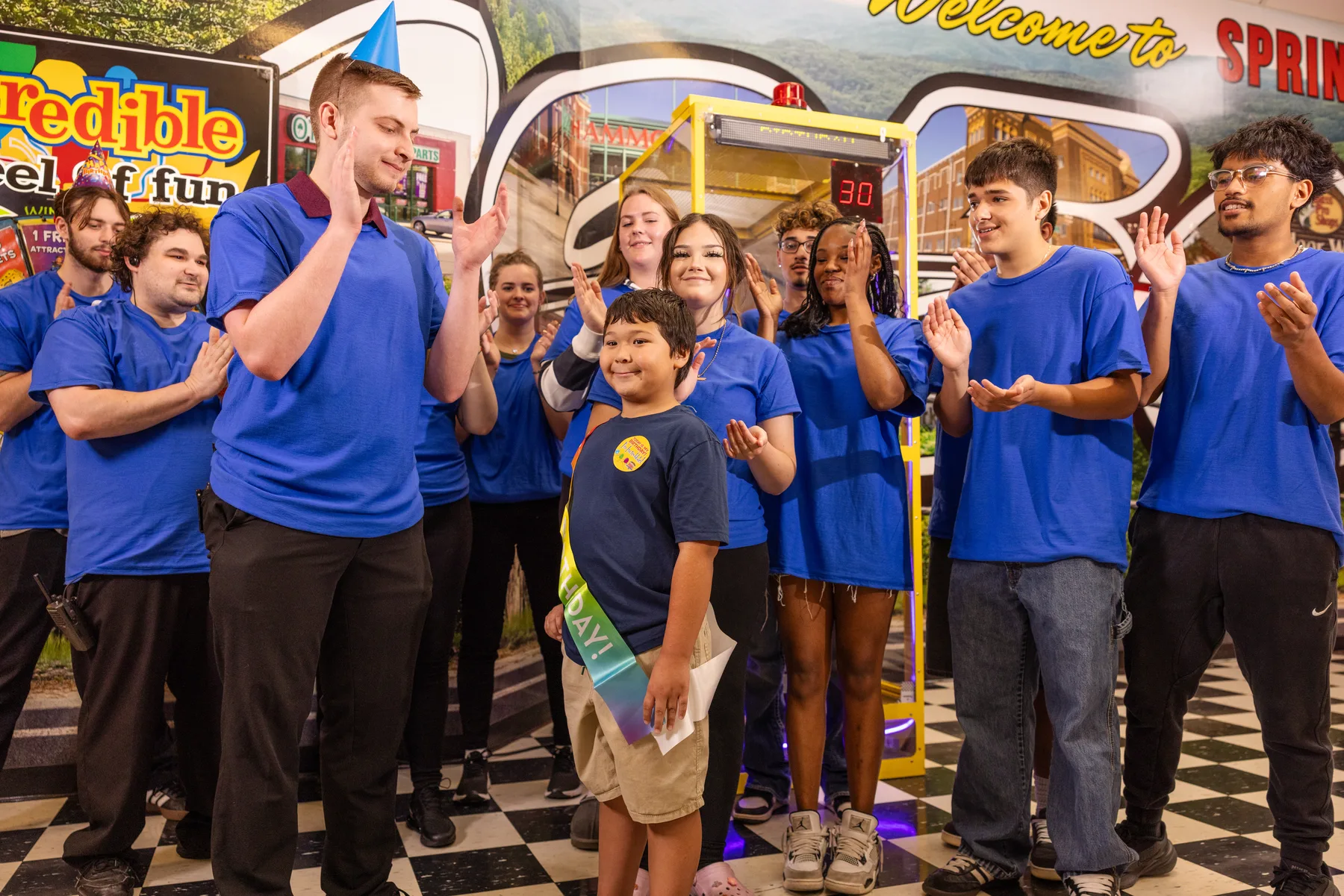 Incredible Food and Fun team members celebrating with a young guest inside the Springfield location
