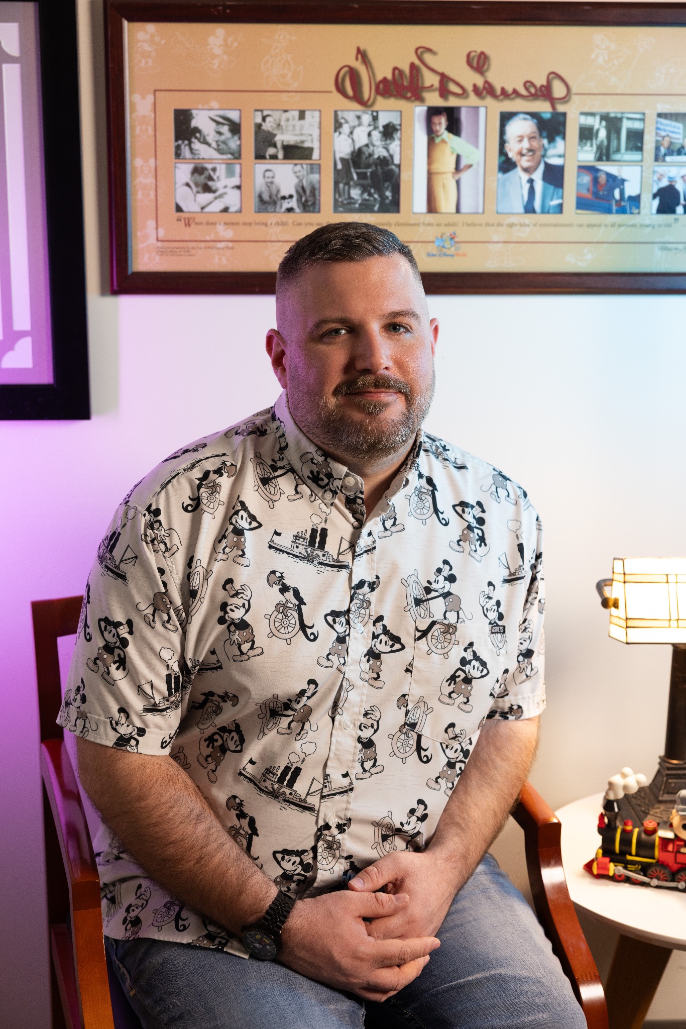 Ryan Tiffin seated beneath a framed Walt Disney display