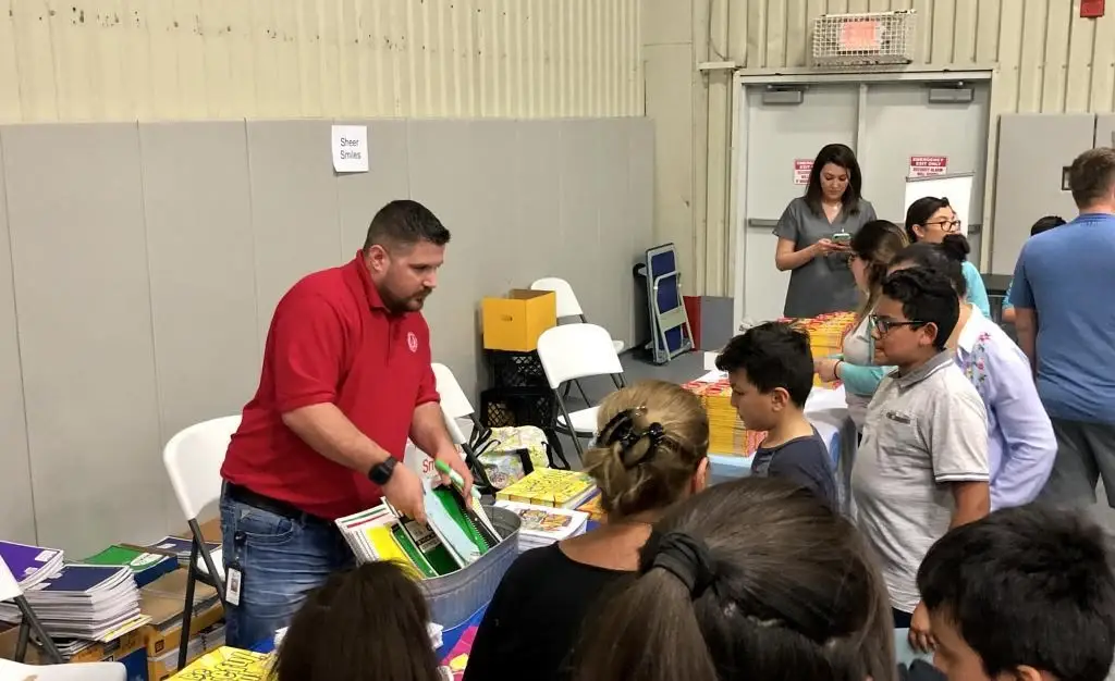 Ryan Tiffin helping guests at a community event, representing clear service handoffs, ownership, and continuity in the guest experience.