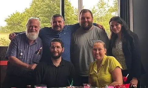 Team members gathered together, representing clear internal communication, operational alignment, and employee experience.